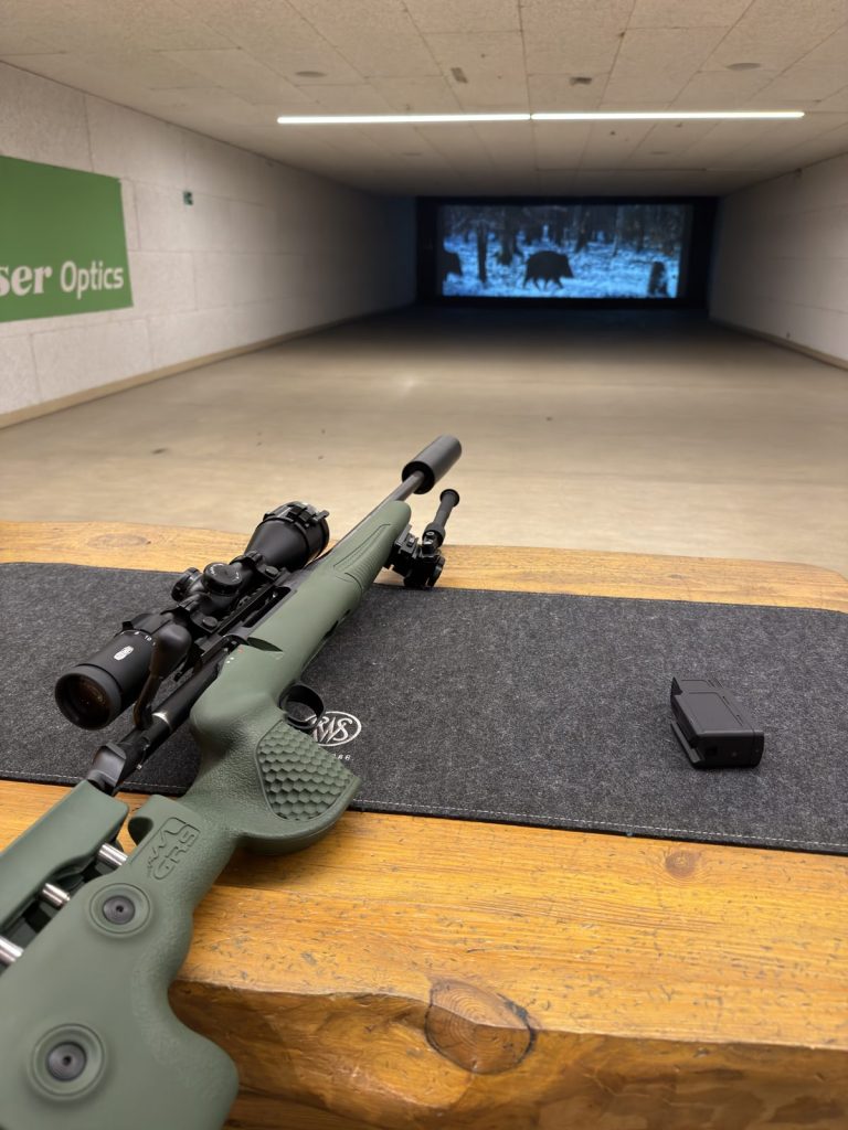 Schießkino Waffen Müller in Hirschfeld: Schießtisch mit Büchse, auf der Leinwand Wildschweine